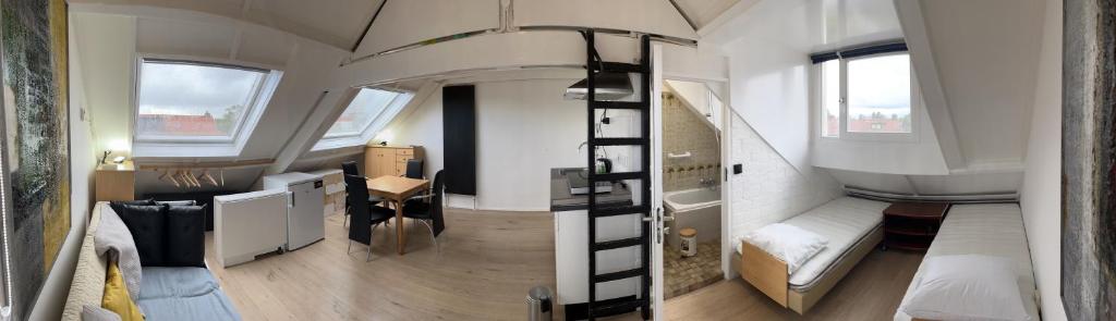 een kleine kamer met een stapelbed en een kamer met een bureau bij Studio met eigen badkamer en eigen keuken in Nijmegen
