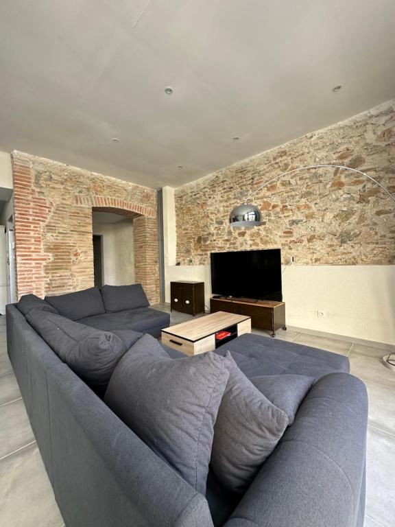 un salon avec un canapé bleu et une télévision dans l'établissement La Casita, à Torreilles