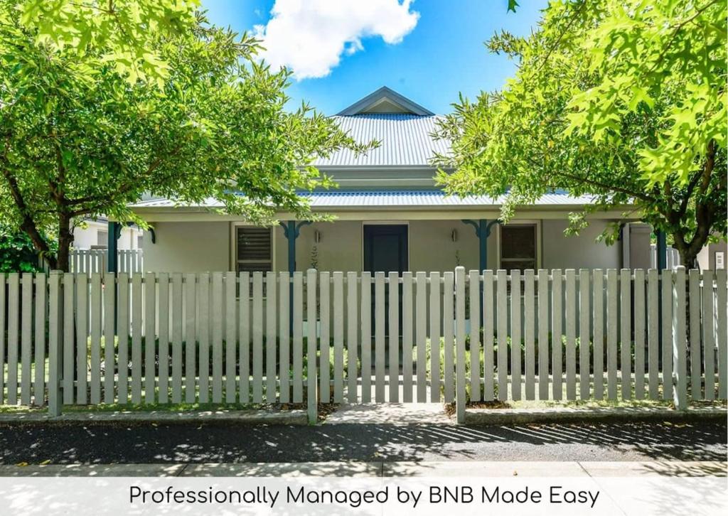 a white fence in front of a white house at The Sampson Haven - Luxe CBD Getaway, Dog Friendly in Orange