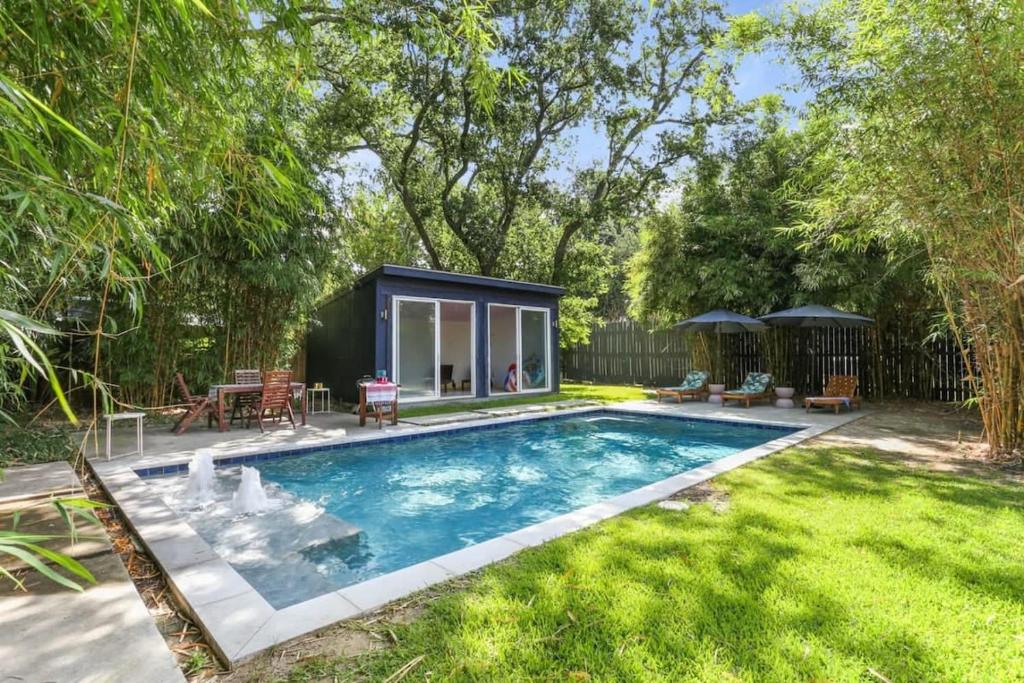 a tiny house in a garden with a swimming pool at Gorgeous backyard Pool 2BD Midcity Retreat in New Orleans