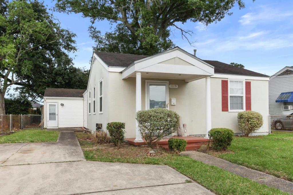 a white house with red shutters at 4BD Metairie retreat with driveway and yard in Metairie