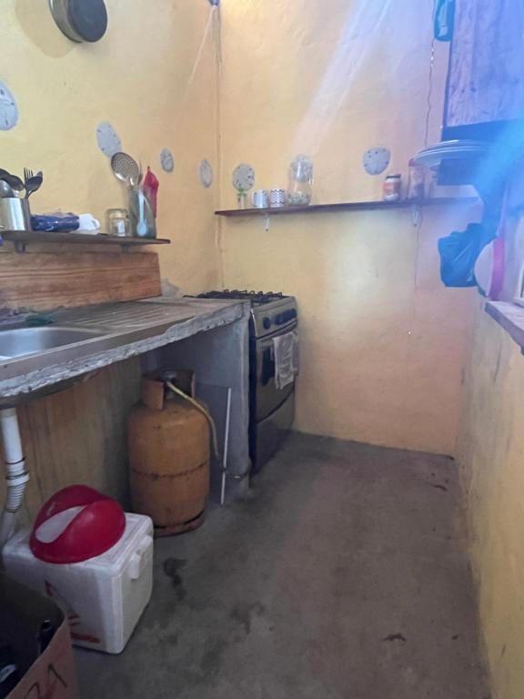 a small kitchen with a sink and a stove at Casita con linda jardín a 1minutos de la playa in Las Tunas
