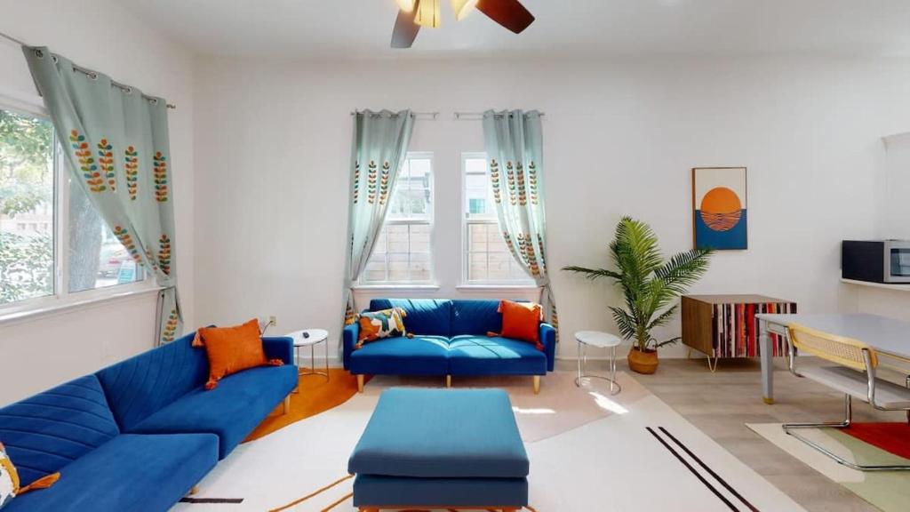 a living room with a blue couch and a table at Sunny 5Bed w Parking and direct Streetcar access in New Orleans