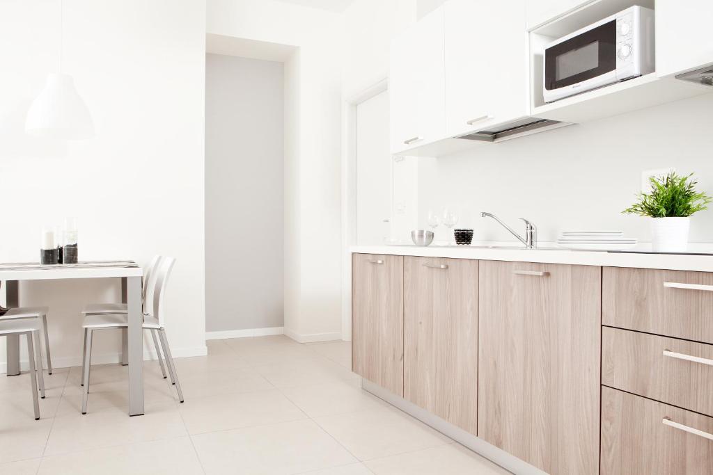 a white kitchen with a sink and a table at Palazzo Talenti 1907 in Trieste