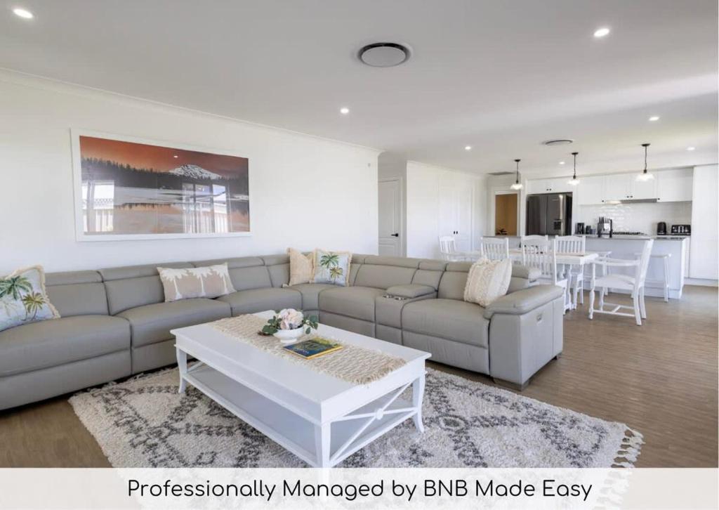 a living room with a couch and a table at The Hideaway - Close to Zoo & Golf Club in Dubbo