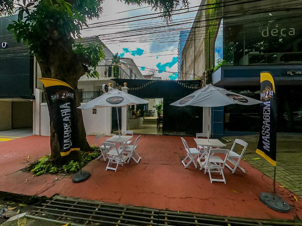 een groep stoelen en parasols naast een boom bij Hotel Filha do Cacique in Belém