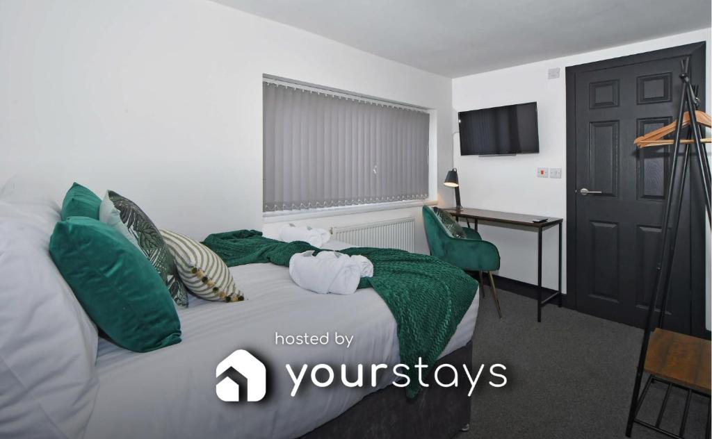 1 dormitorio con cama con almohadas verdes y escritorio en Adventure Place by YourStays en Stoke on Trent