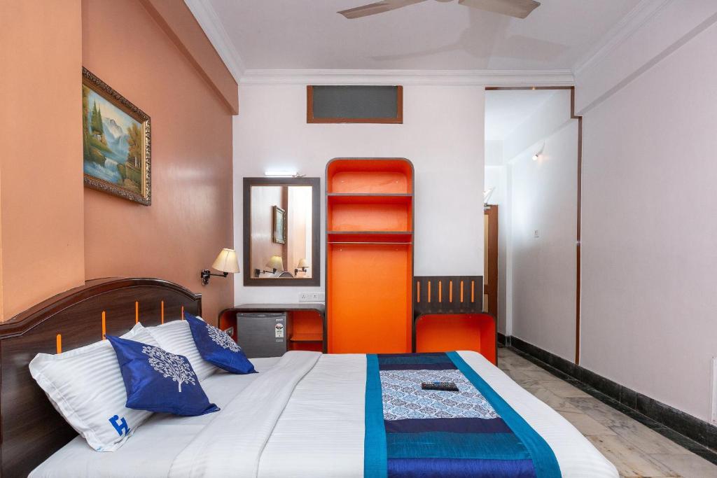 1 dormitorio con 1 cama con almohadas azules en Collection O 5377 Hotel Raaj Bhaavan, en Chennai