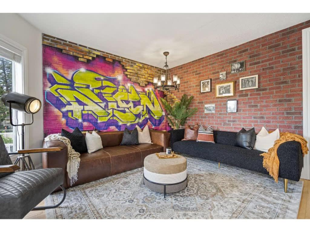 sala de estar con sofá y pared de ladrillo en The Prohibition I Heritage Home I Sleeps 10 I TV, en Cranbrook