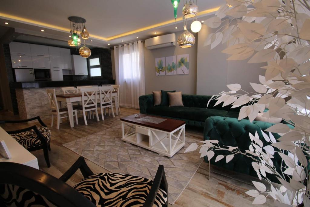 een woonkamer met een groene bank en een tafel bij Blueberry apartment in katameya in Caïro