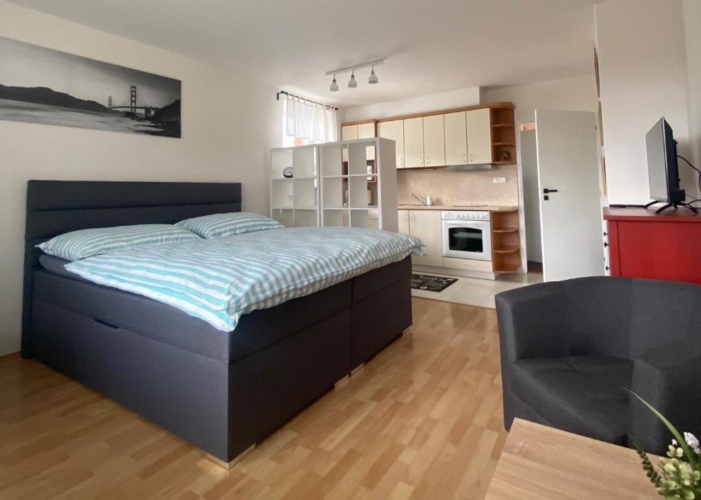 a large bedroom with a large bed and a chair at Apartmán U Onky in Luhačovice