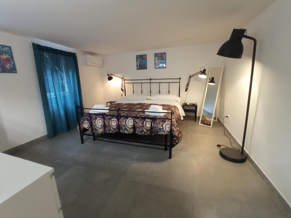 een slaapkamer met een bed en een lamp erin bij GrotteBianche - Sicilian Apartment in Catania
