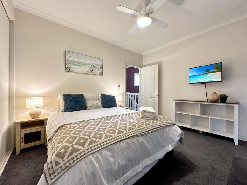 a bedroom with a bed and a ceiling fan at Little Malop Escape I Central Geelong in Geelong