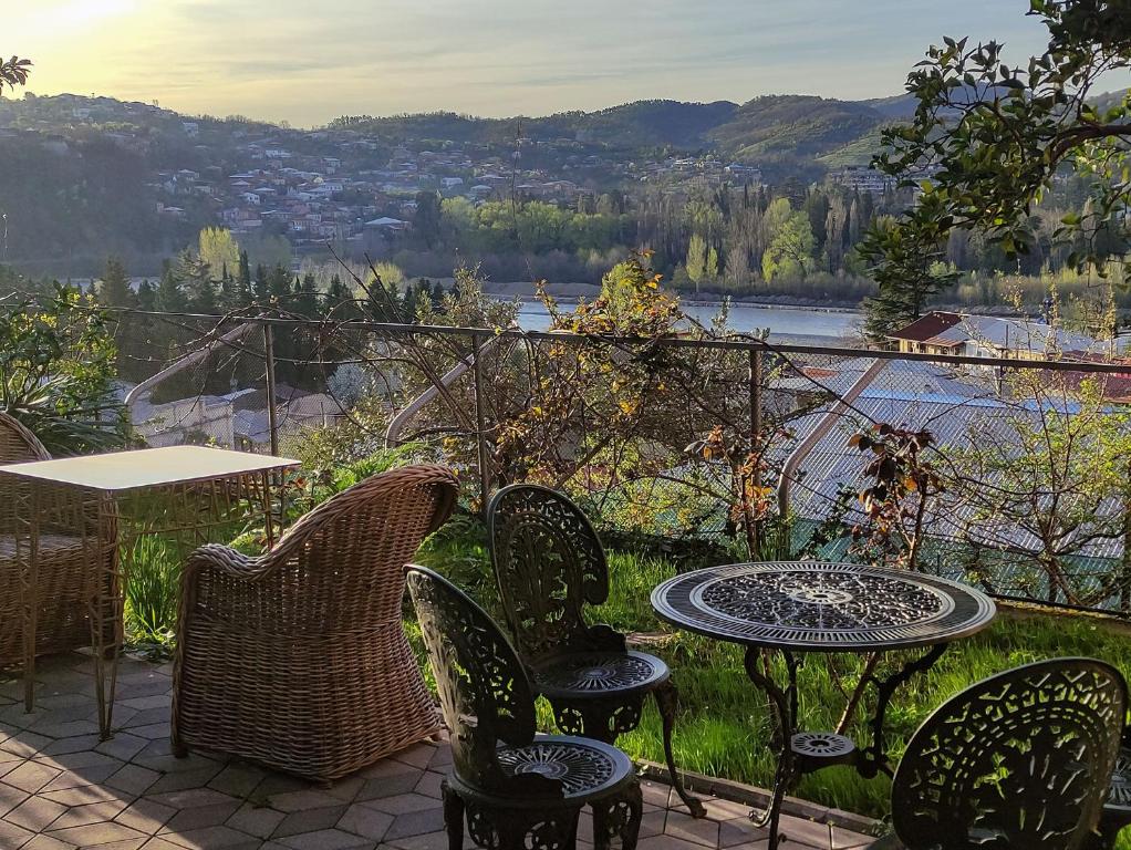 an outdoor table and chairs with a view of a river at Veranda Boutique Hotel Kutaisi in Kutaisi