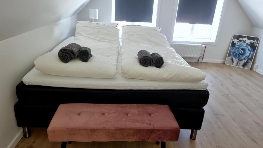a white bed with two pairs of shoes on it at Itilleq in Sisimiut