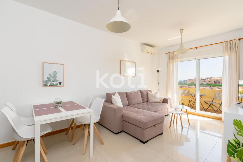 uma sala de estar com um sofá e uma mesa em Koti Rentals - Nenúfar em Fuengirola