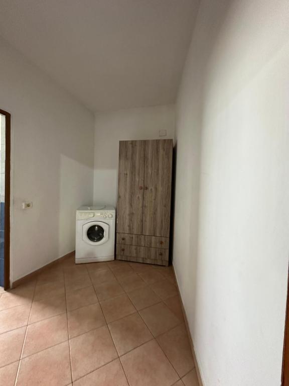 una sala de lavandería con lavadora en una habitación en Shabani en Tirana
