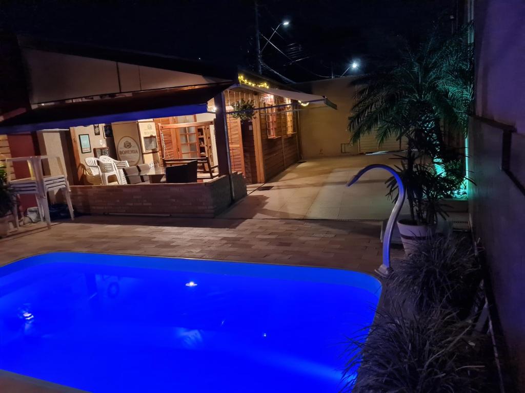 a blue swimming pool in a yard at night at Rancho da Malu in Taubaté