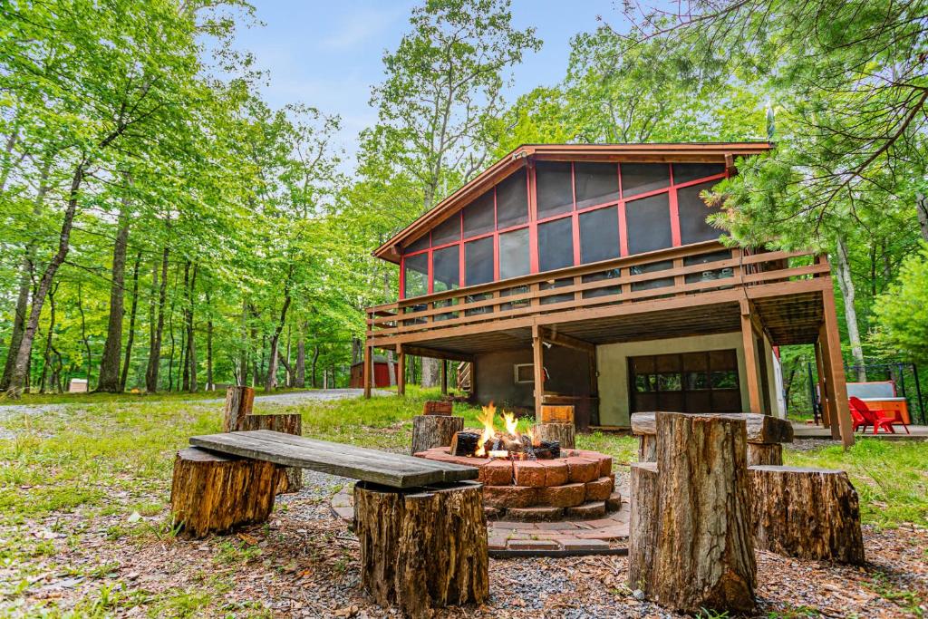 a cabin in the woods with a fire pit and logs at Hot Tub, River&Kayak, WiFi, & Fire Pit at Cabin! in Morton Grove