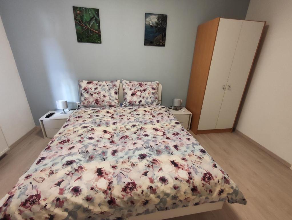 a bedroom with a bed with a floral bedspread at Kuća za odmor EMA in Šibenik