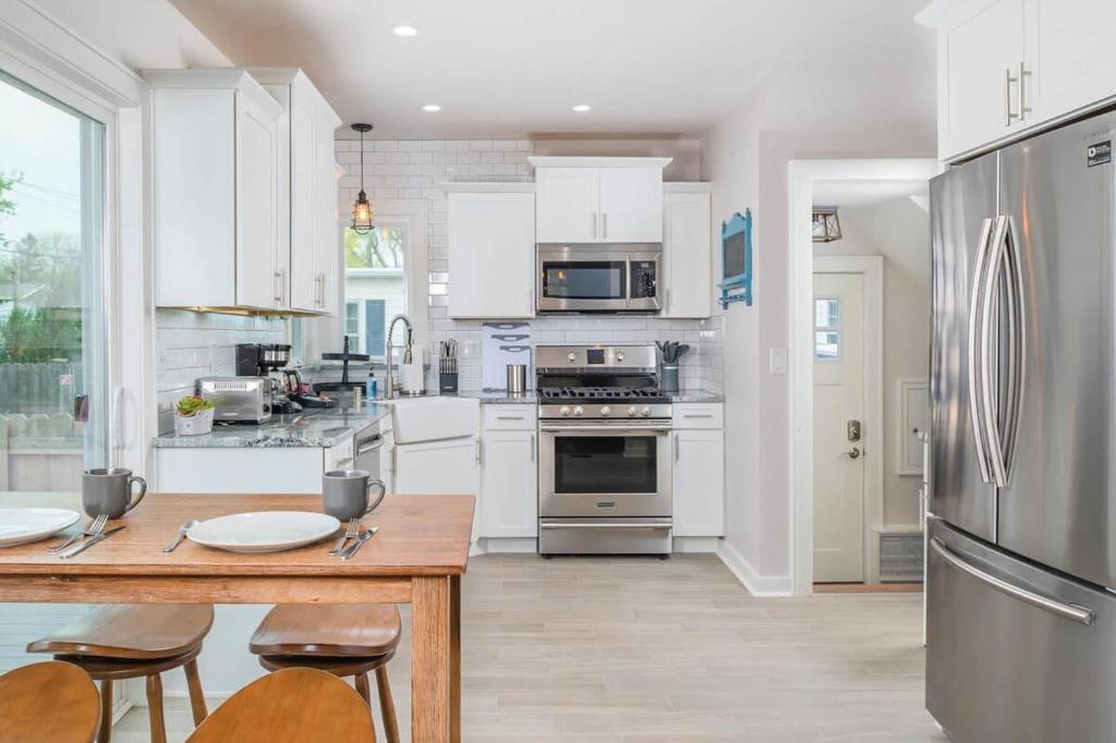 uma cozinha com armários brancos e um frigorífico de aço inoxidável em Aʟɪᴄɪᴀ Sᴛʀᴇᴇᴛ Aғғʟᴜᴇɴᴄᴇ - Luxury Home em Appleton