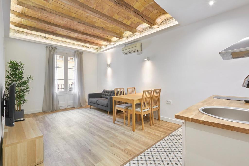 a kitchen and living room with a table and a couch at Ro Lively and bright apartment next to Blai st in Barcelona