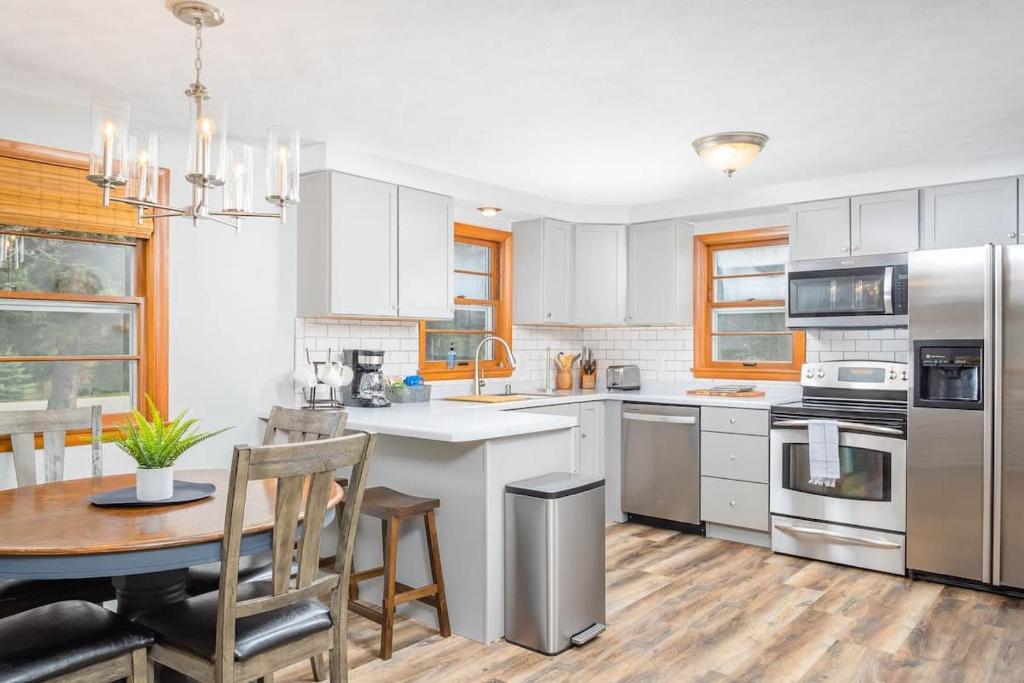 une cuisine avec des placards blancs, une table et une salle à manger dans l'établissement - 3 bedroom 2 bath, à Appleton