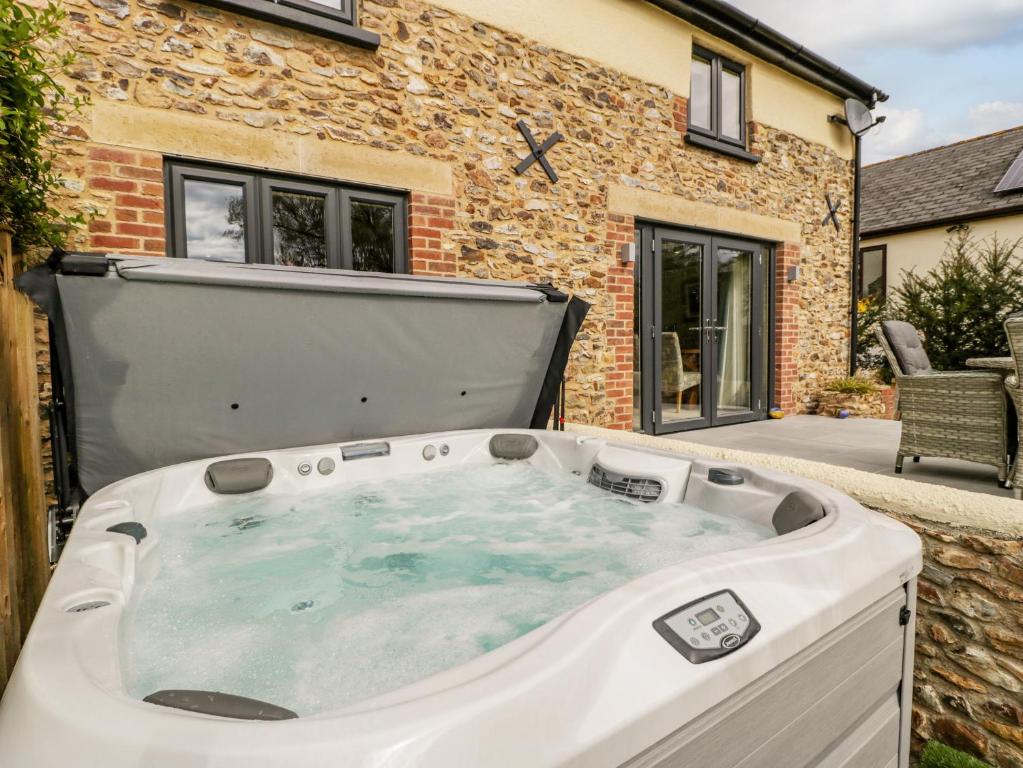 a hot tub in the backyard of a house at Forever Home in Honiton