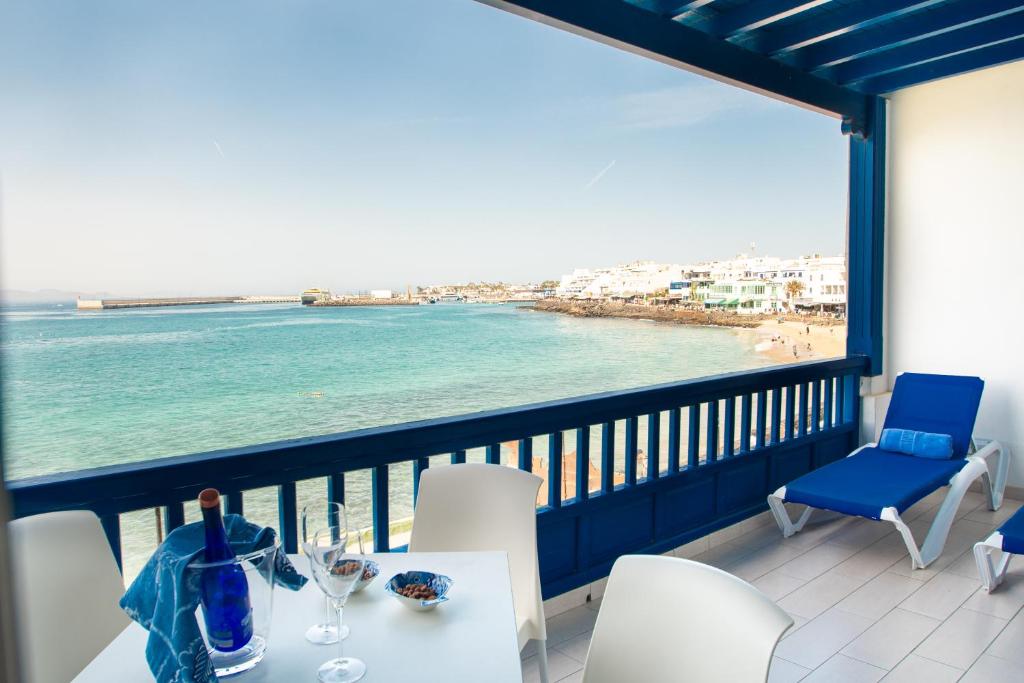 balcón con mesa, sillas y vistas al océano en Blancazul Alto Brisa, en Playa Blanca