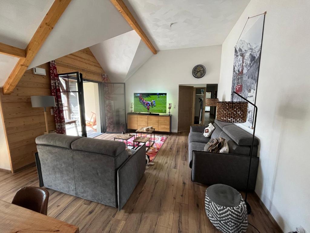 sala de estar con 2 sofás y TV en T4 Saint Lary, en Saint-Lary-Soulan
