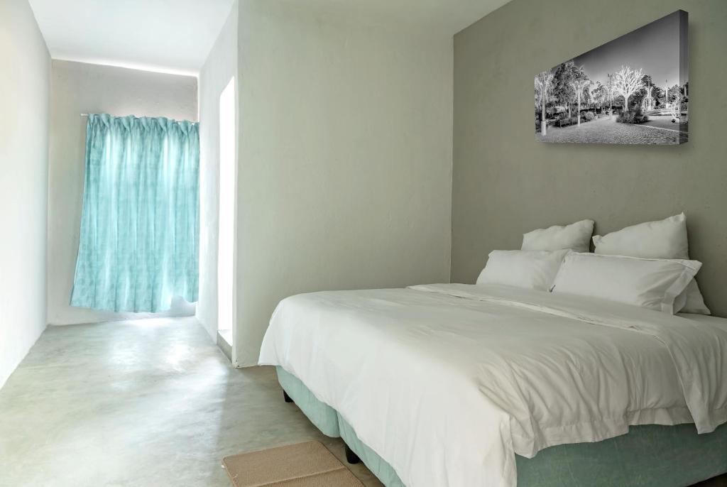 Un dormitorio con una gran cama blanca y una ventana en White Oak Place, en Katoen