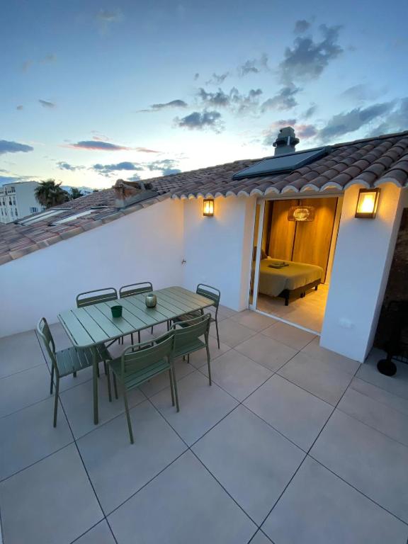 un patio avec une table et des chaises sur un toit dans l'établissement « L’Observatoire » 6 personnes, à Bandol