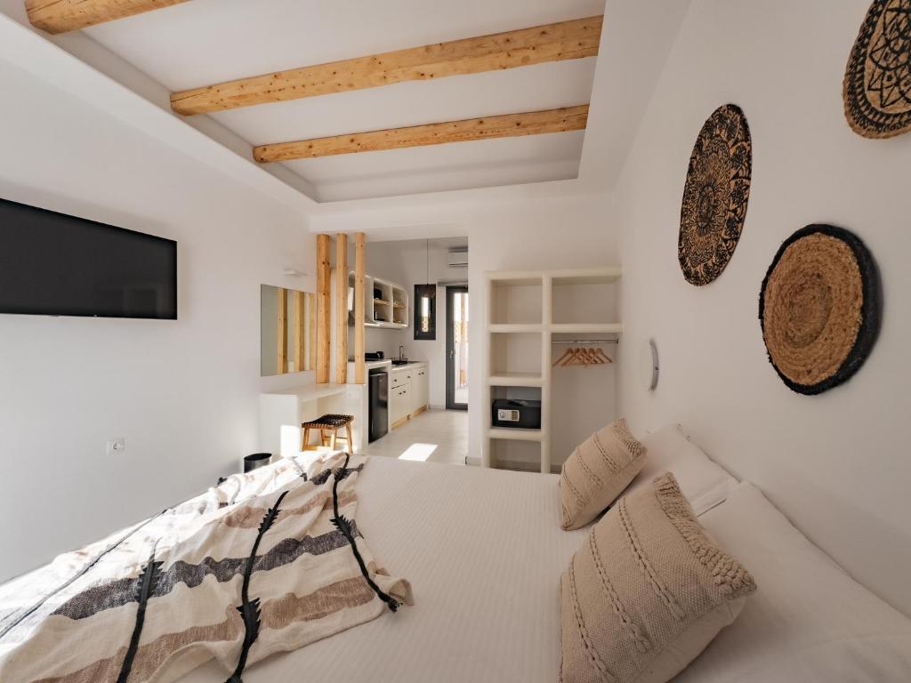 Schlafzimmer mit weißen Wänden und einem Bett mit Kissen in der Unterkunft Alonia Suites in Naoussa