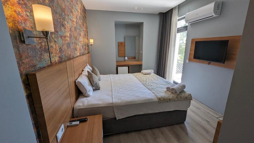 a hotel room with a bed and a television at Antalya Ramona in Antalya