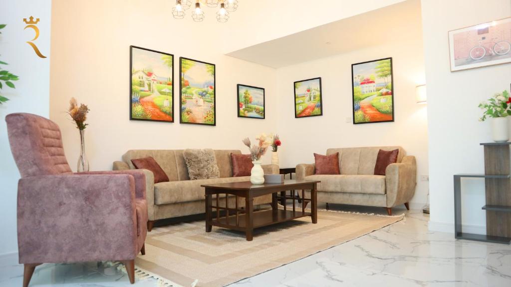 a living room with two couches and a table at Meadow 3BR Transit Modern Duplex Masdar City in Abu Dhabi