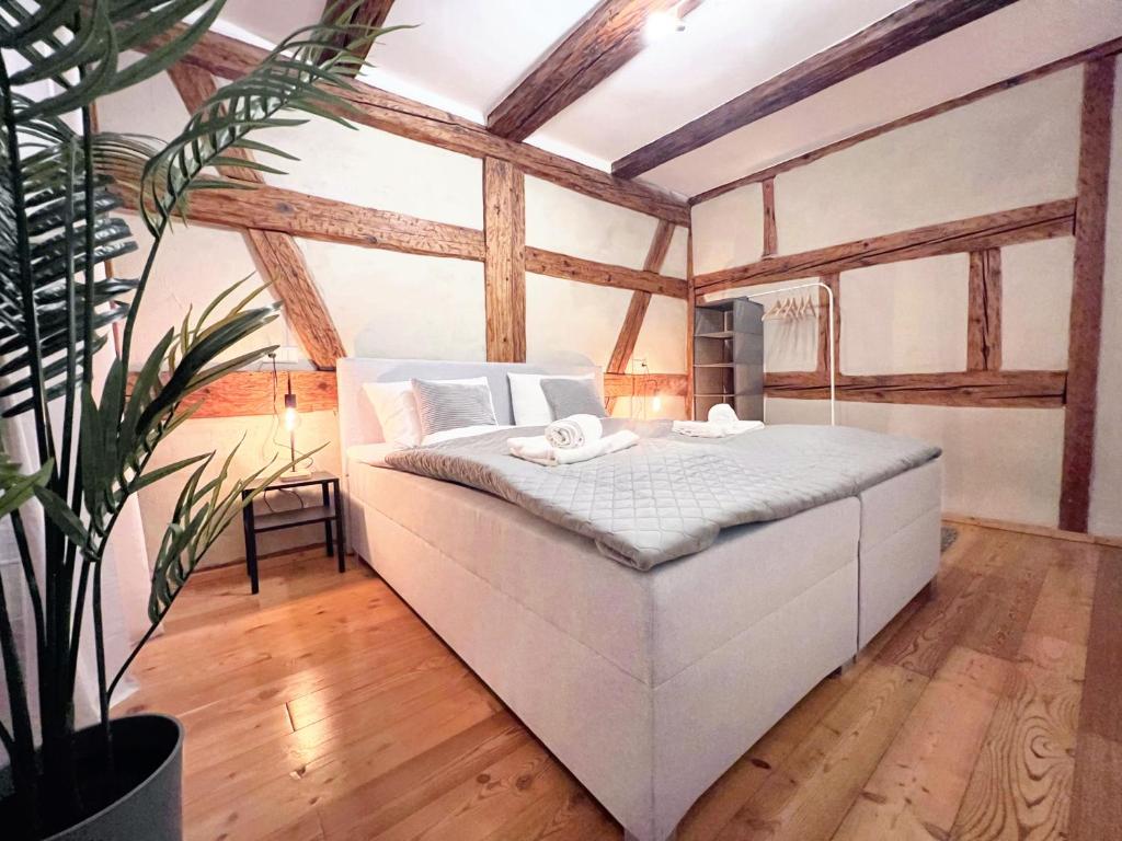 a bedroom with a white bed in a room with wooden ceilings at BackHome - Fantastische Lage, SmartTV, Netflix, 50qm, 24h Checkin - Apartment 5 in Schwäbisch Hall