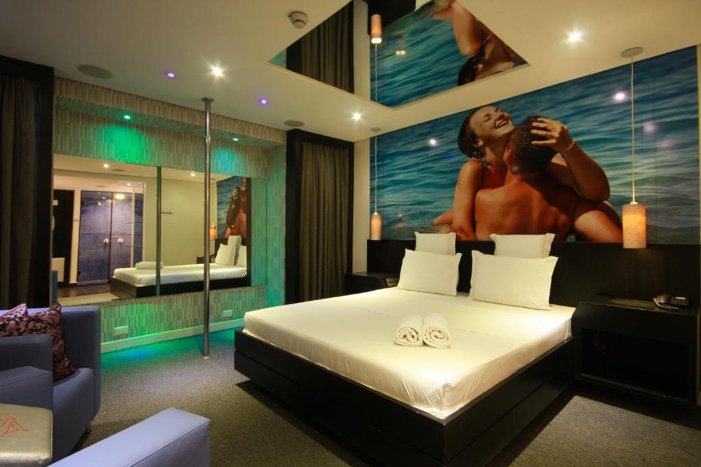 - une chambre avec un lit orné d'une peinture d'une femme nue dans l'établissement Motel Confidence, à Santo André