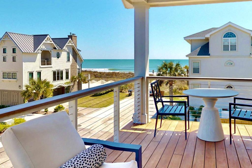 een balkon met stoelen en een tafel en de oceaan bij Oceans 12 in Wrightsville Beach