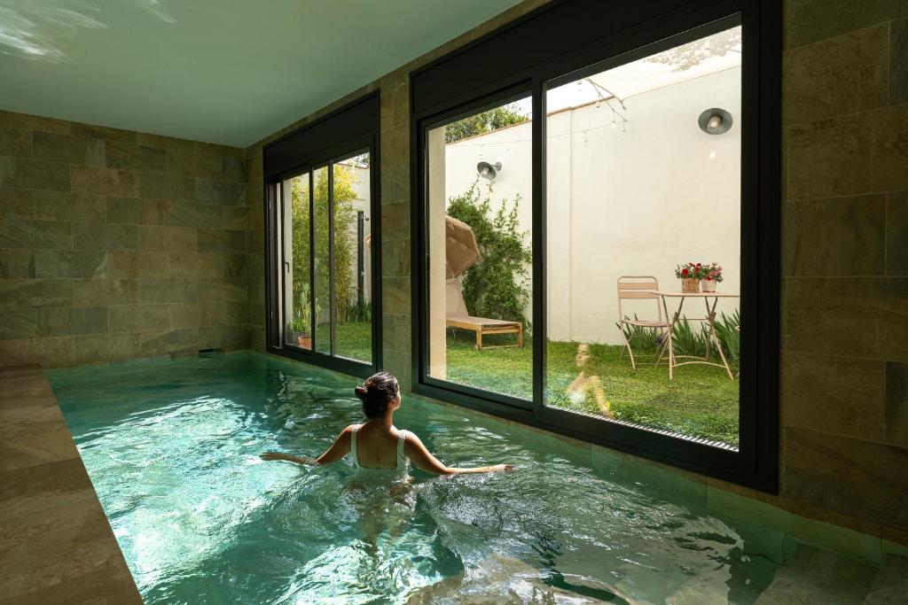 una mujer en una piscina en una casa en Loft con piscina privada climatizada a 5' del Museo Dalí en Figueres