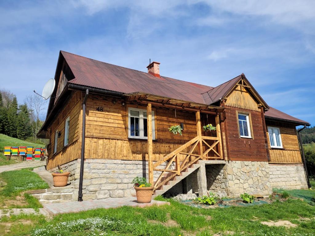 ein Holzhaus mit einem Gameradach in der Unterkunft Stary Dom z Piwnicą in Krynica-Zdrój