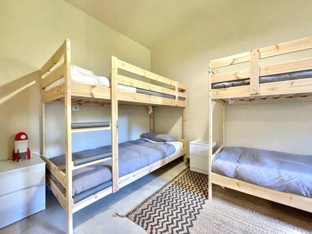 a bedroom with two bunk beds and a rug at La Casa da Pipa in Cesuras