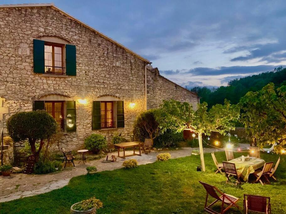 una casa de piedra con una mesa y sillas en el patio en Maison en Provence au bord de la rivière, en Montfrin