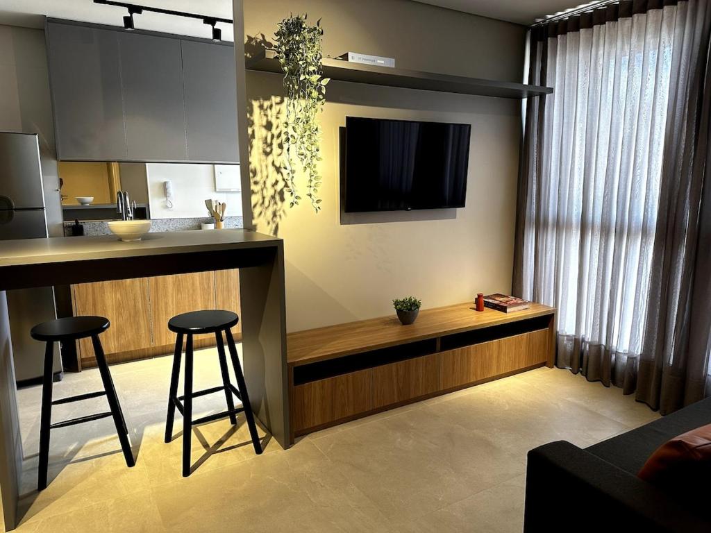 a kitchen with a counter and a bar with stools at PARK SUL - Edifício Essence - 7 in Brasília