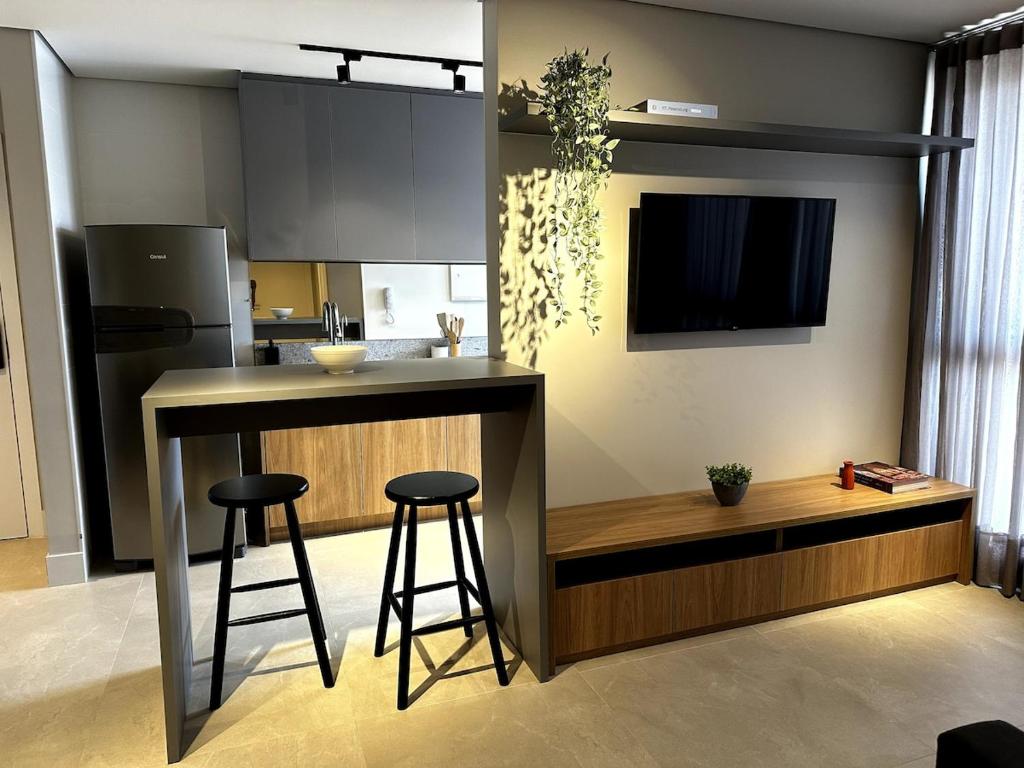 uma cozinha com um bar com dois bancos e um balcão em PARK SUL - Edifício Essence - 10 em Brasília