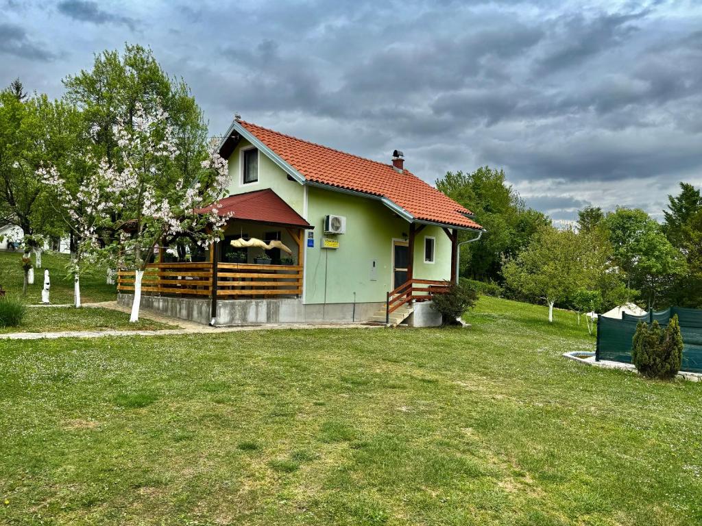 ein kleines Haus mit einem Zaun im Hof in der Unterkunft Apartment Valentina in Bročanac