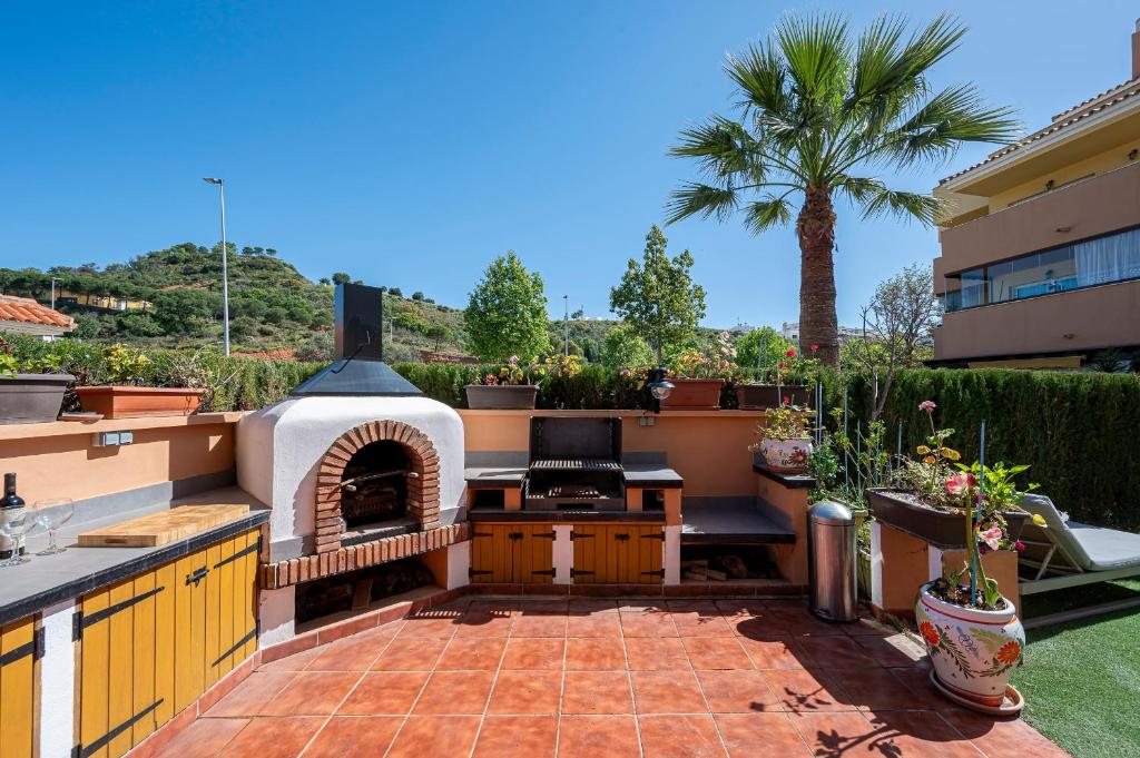 an outdoor kitchen with a pizza oven on a patio at La Cala golf and Sun apartment in Mijas