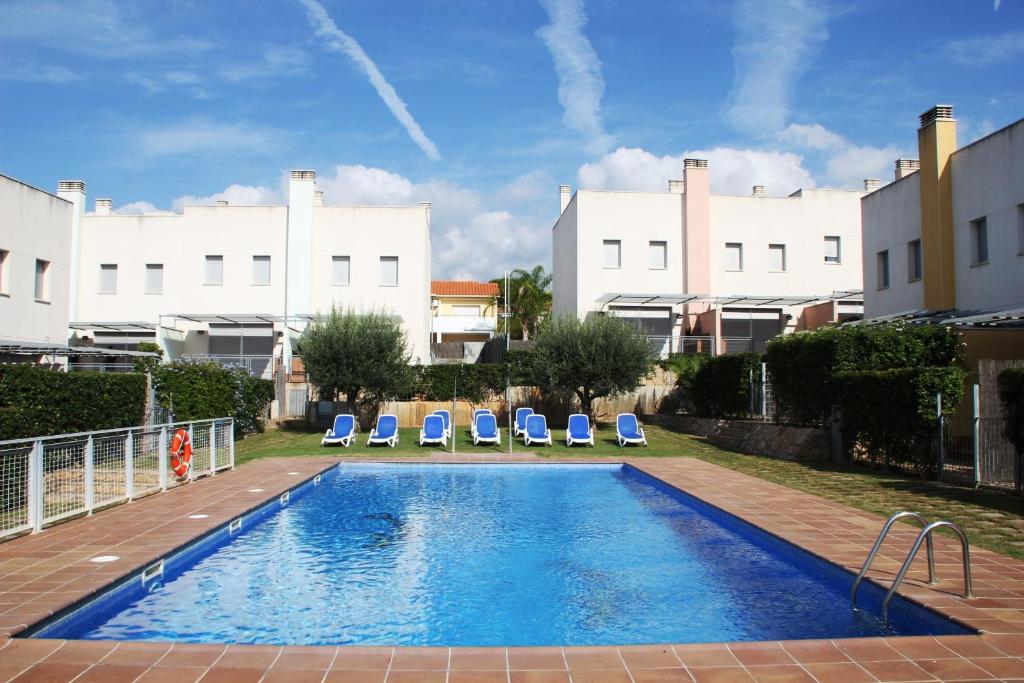 una piscina con 2 tumbonas y un edificio en Hotur Via Augusta, en Creixell