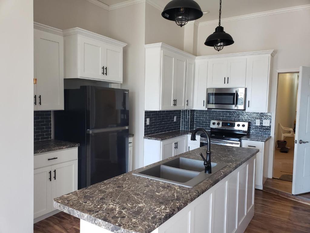 a kitchen with white cabinets and a sink at Riverview in Fort Madison in Fort Madison