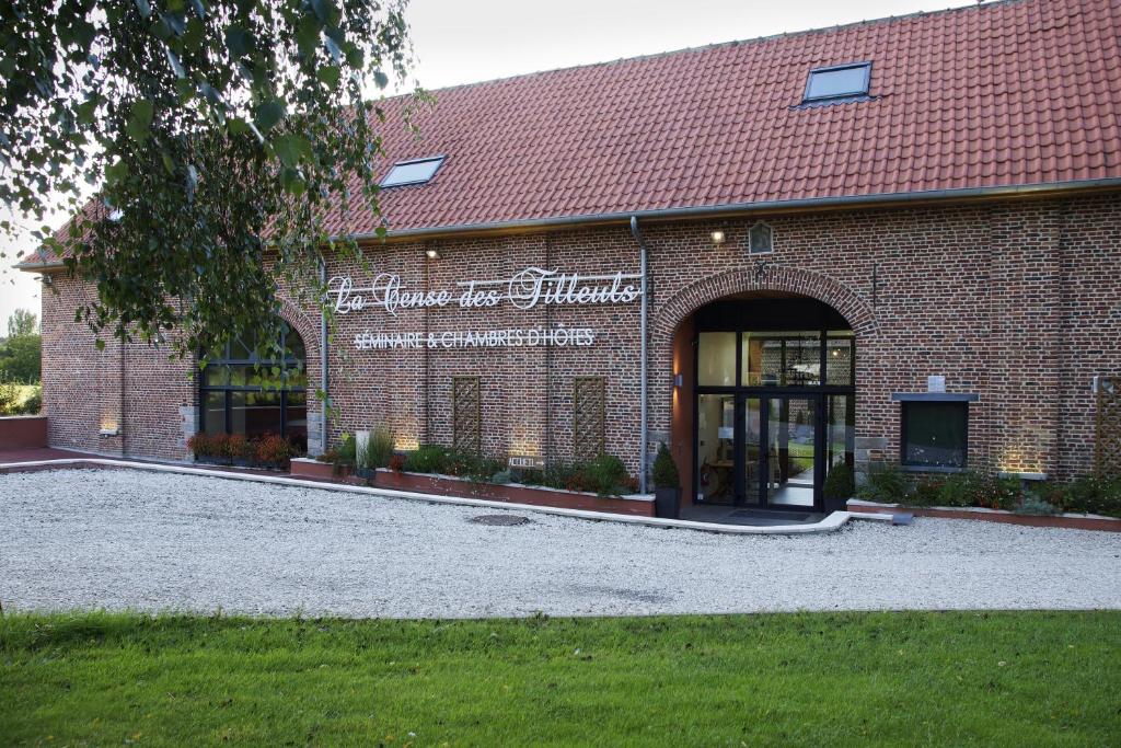 a brick building with a sign on the front of it at La Cense - Ferme des Tilleuls in Houplines