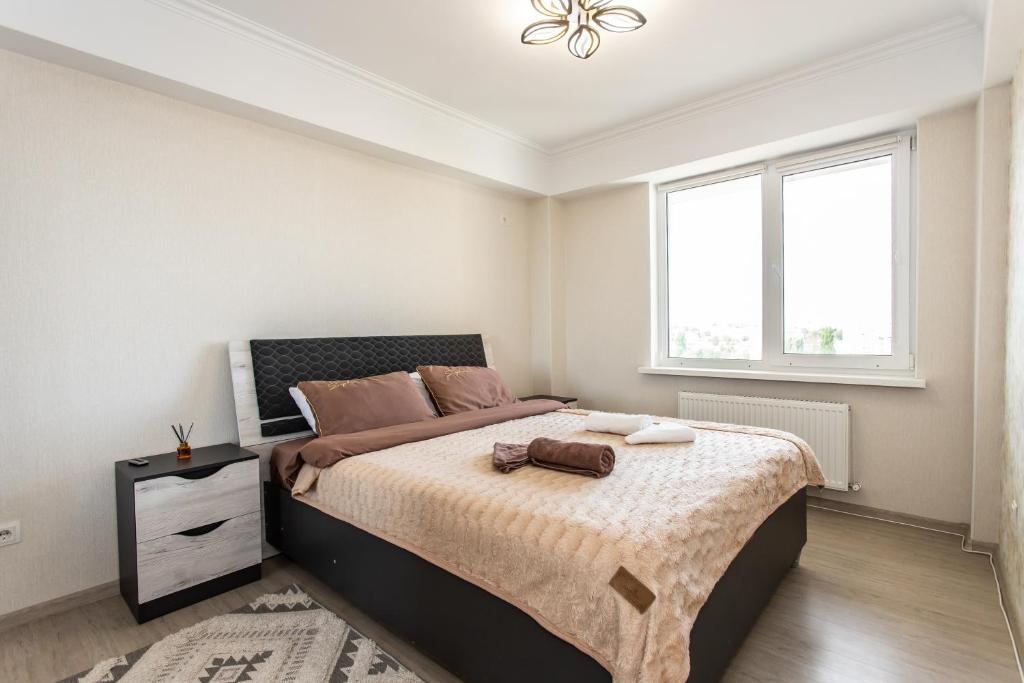 een slaapkamer met een groot bed en een raam bij Apartment For You in Chişinău